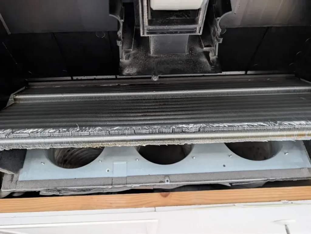 天井埋め込み型エアコンの熱交換器(エバポレーター)部分を近距離で撮影した写真。内部のフィンやダクトが見える状態。