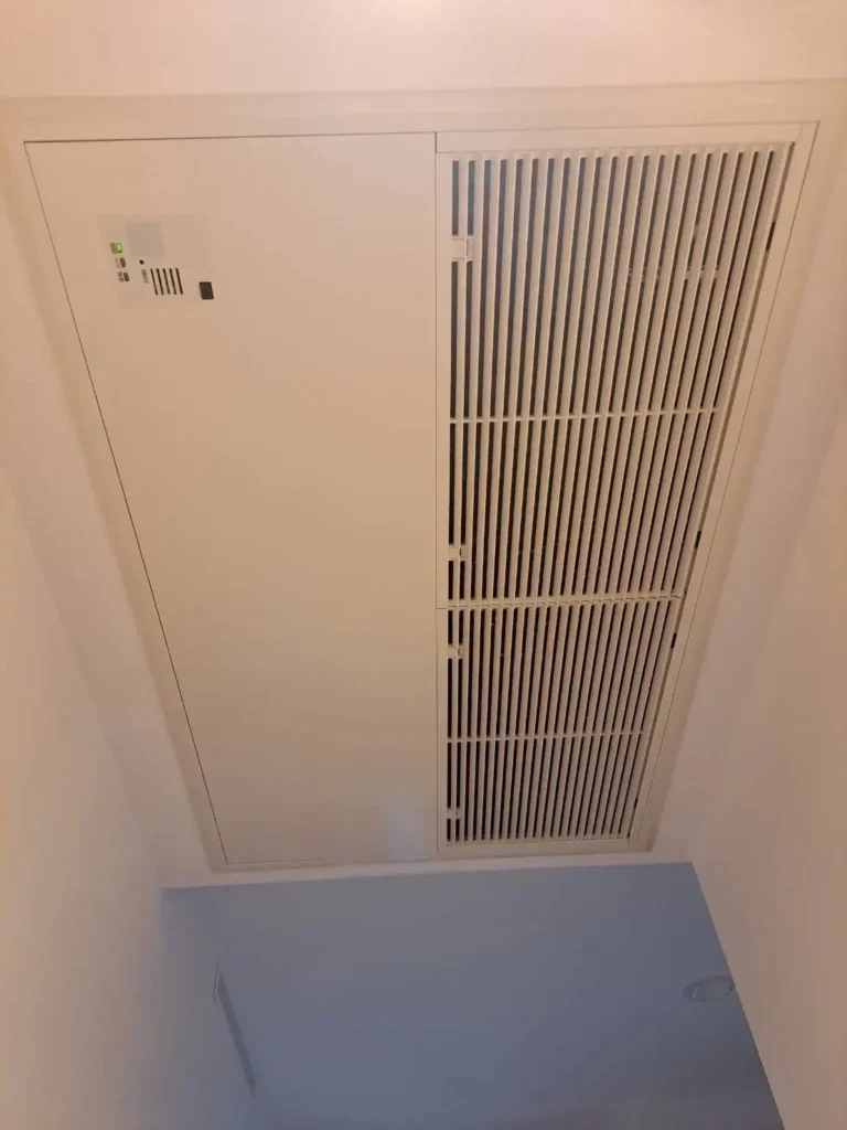 天井埋め込み型エアコンのフロントパネルと吸込みグリルが閉じた状態の写真。